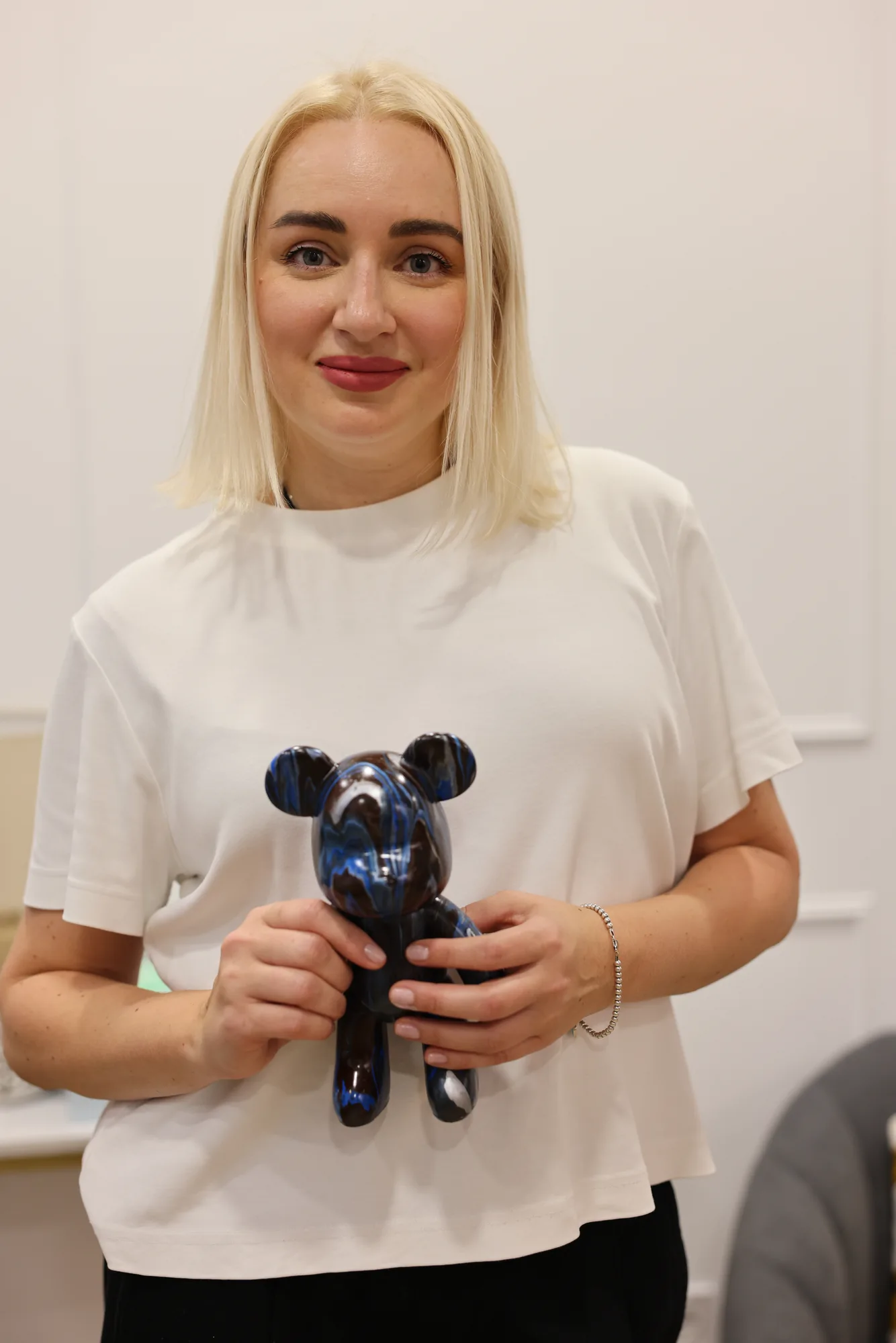 Adult visitor presenting her finished fluid art bear
