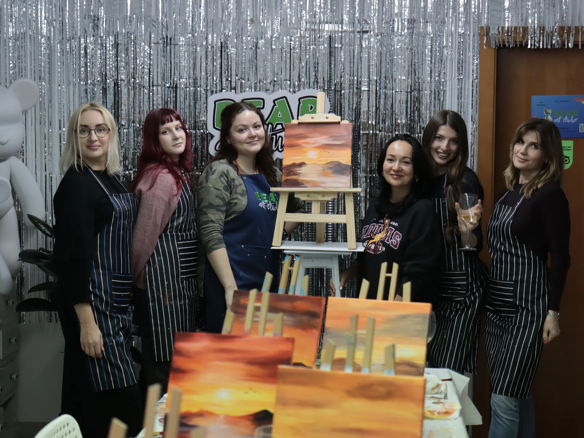 Adult group presenting their warm sunset paintings