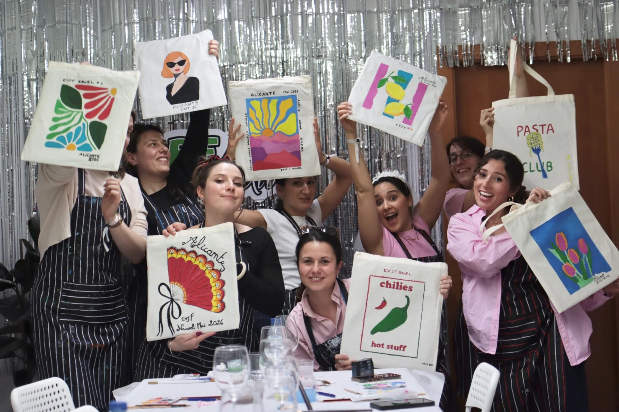An adult group presenting hand-painted tote bags at Bear Art Studio Alicante