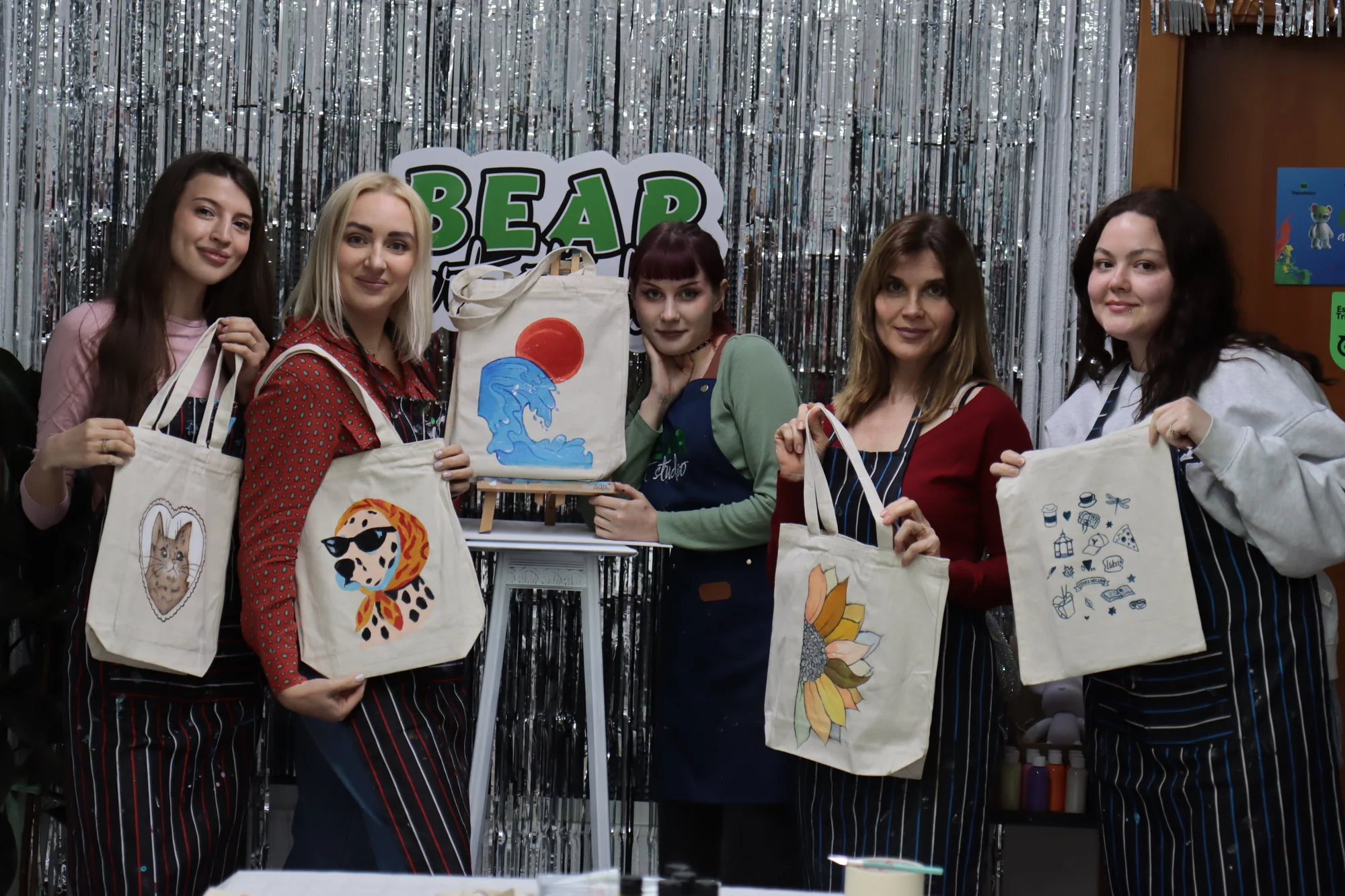 Adult group presenting their hand-painted tote bags